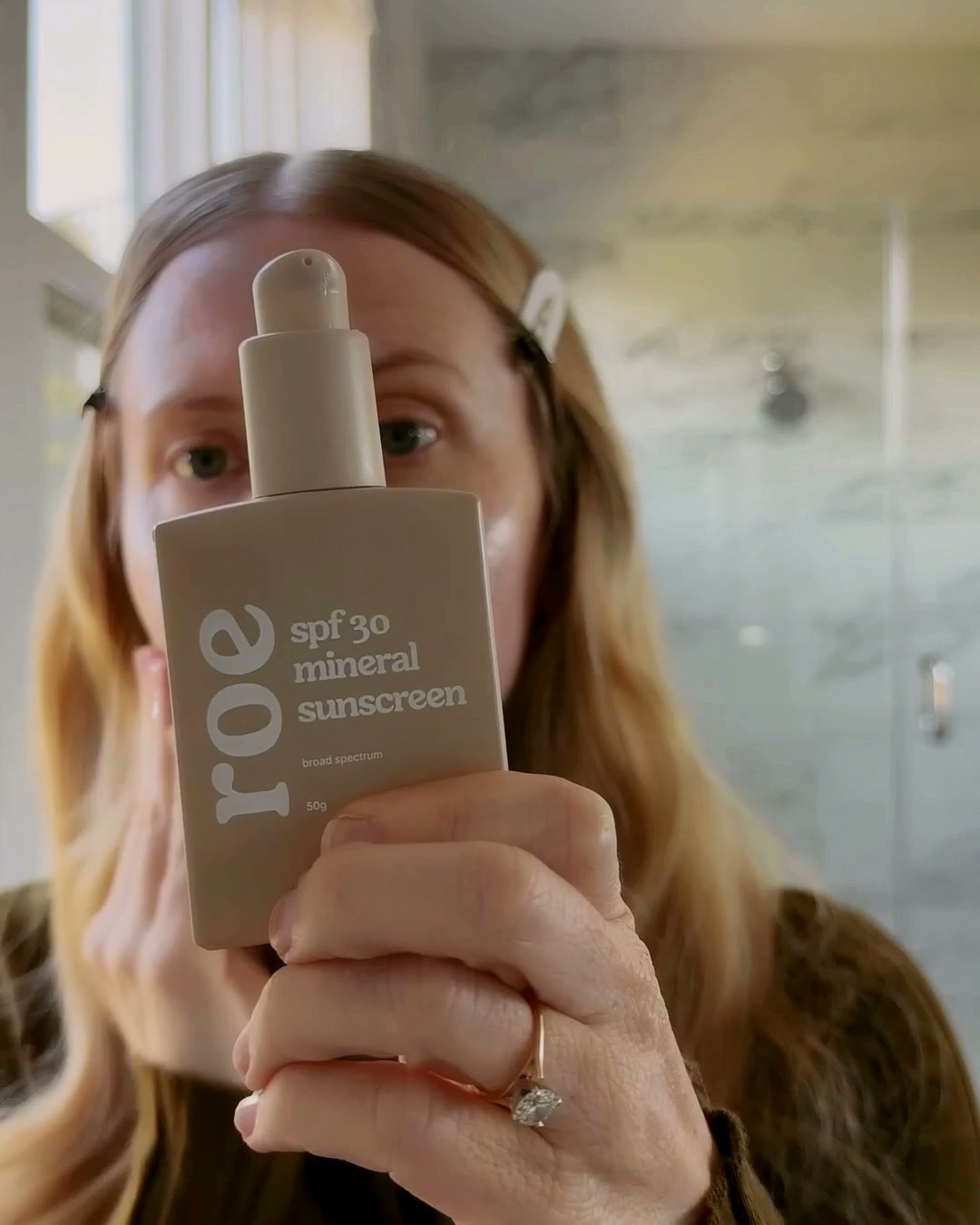 Roe SPF 30 mineral sunscreen held up to the camera